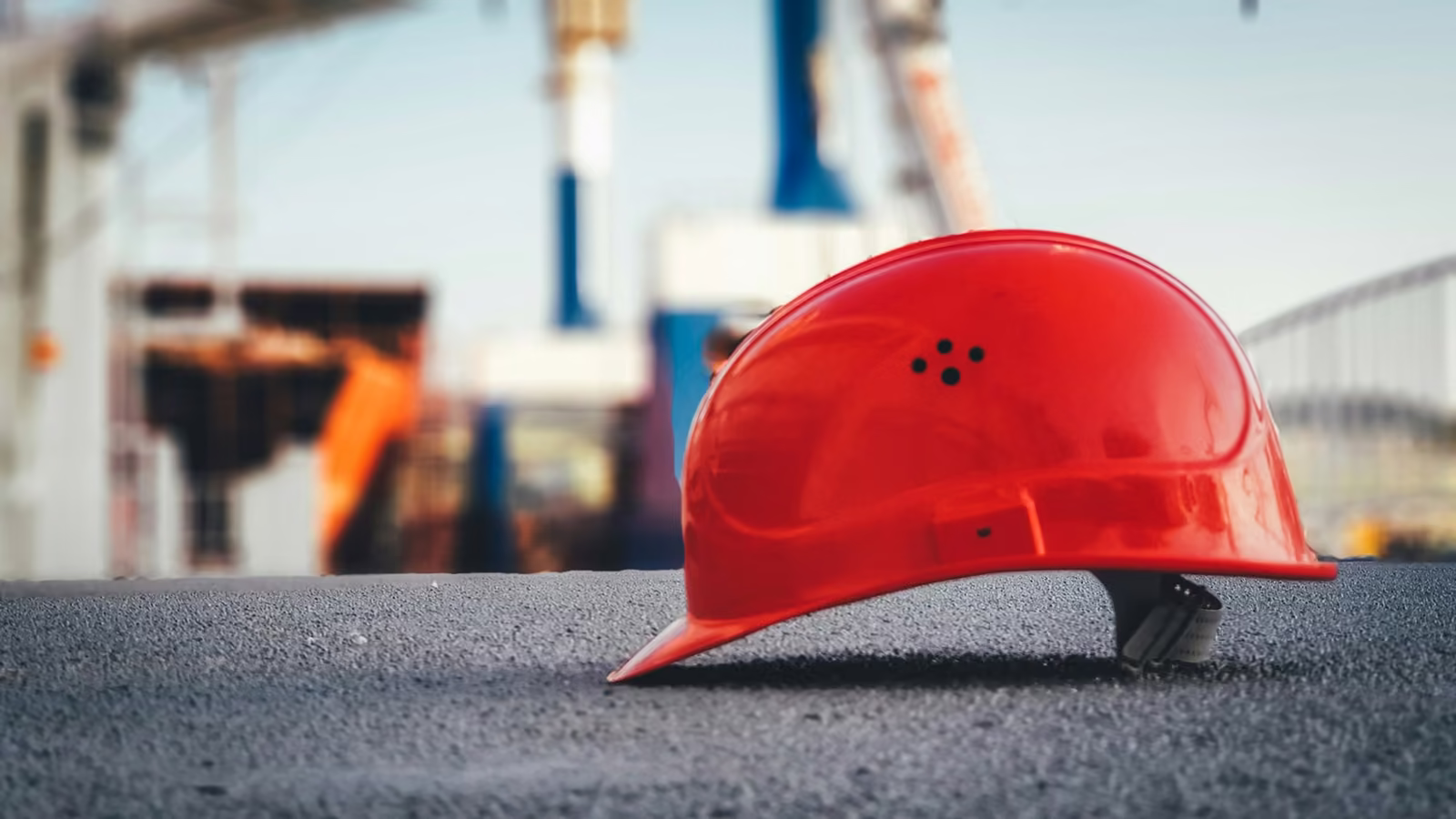 Casco de seguridad rojo sobre el pavimento