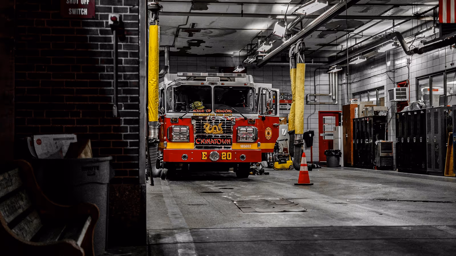 Camión de bomberos rojo estacionado dentro de una estación de bomberos