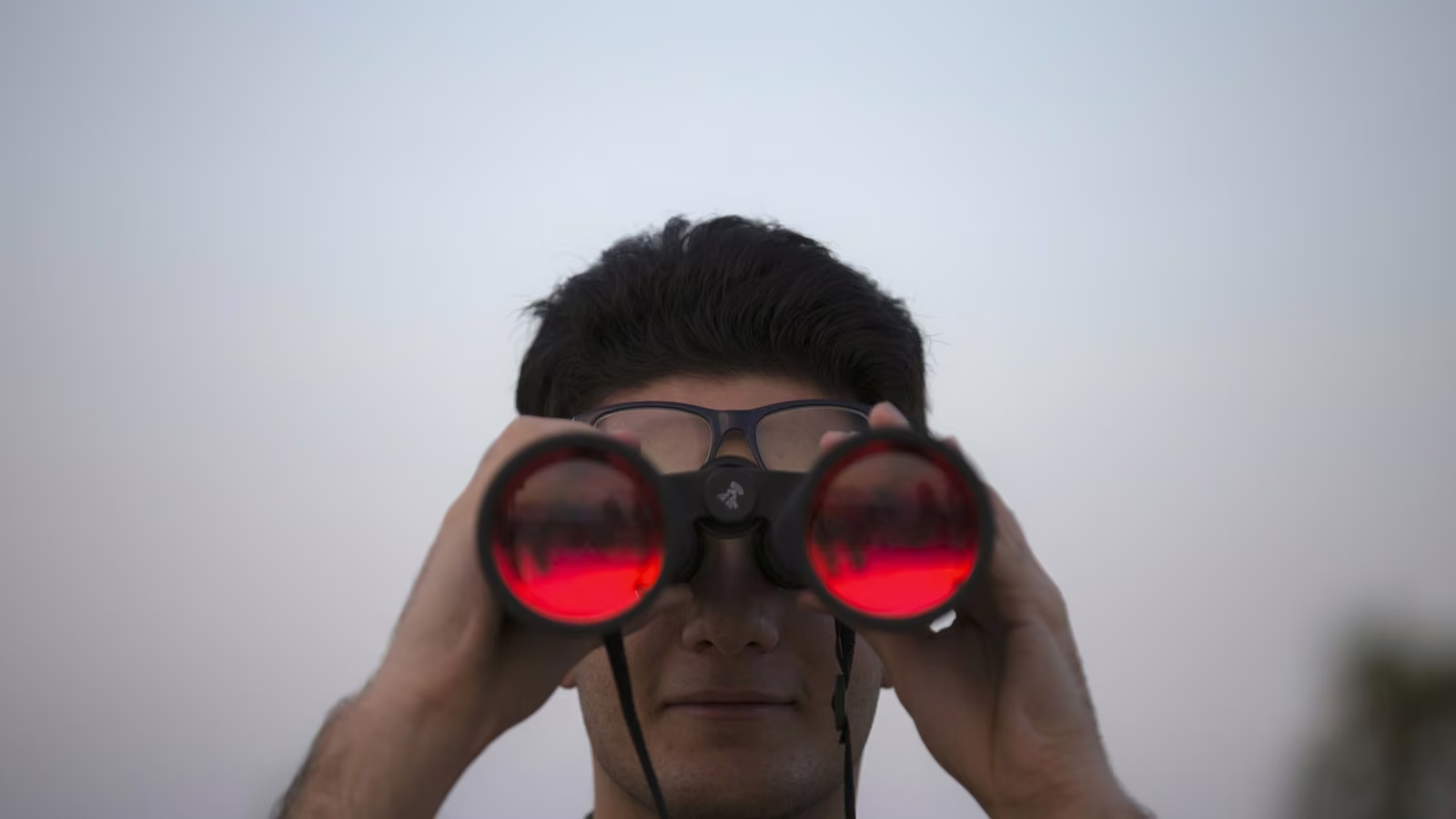 Persona observando a distancia con binoculares