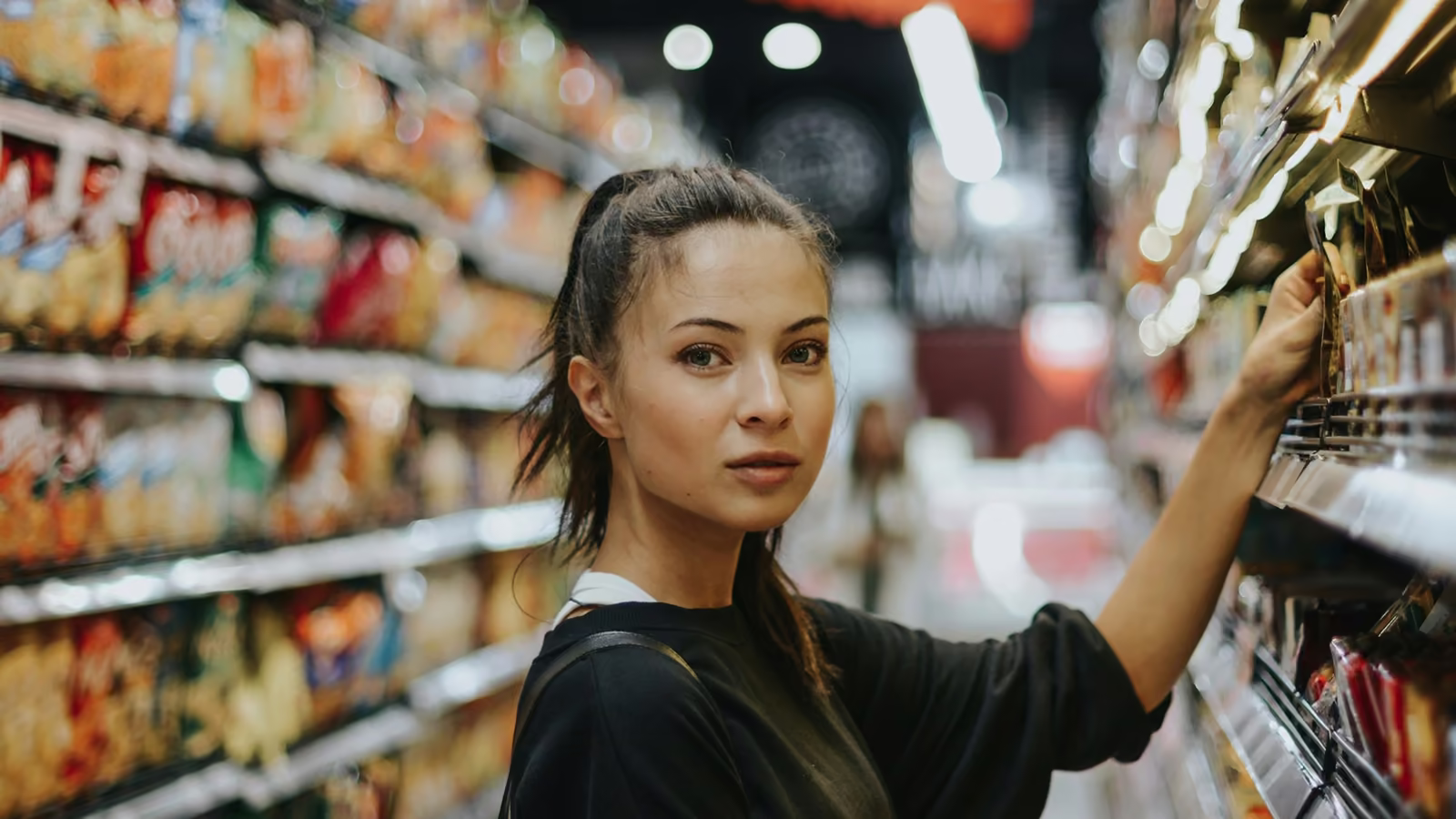 Clienta eligiendo productos en el pasillo de una tienda